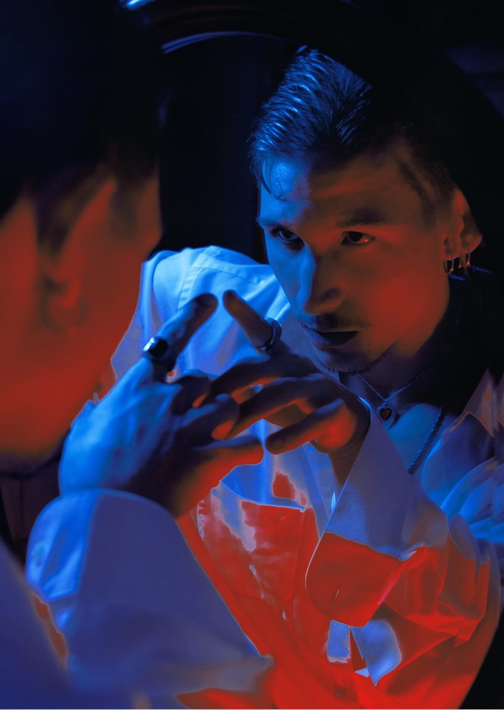 Lucas Gavvi in blue and red light at a mirror